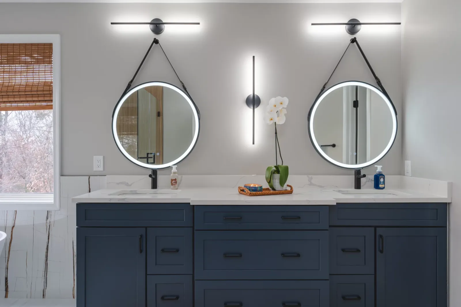 Navy double vanity with round lit mirrors